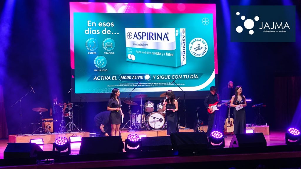 Presentación en el escenario de El Cantoral con pantalla central e iluminación violeta.